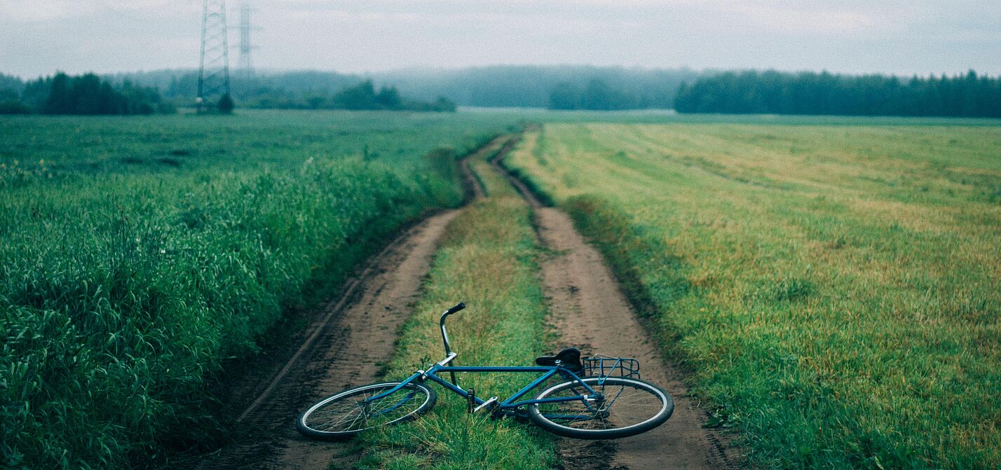 Ein Fahrrad liegt auf einem Feldweg Ein Fahrrad liegt auf einem Feldweg